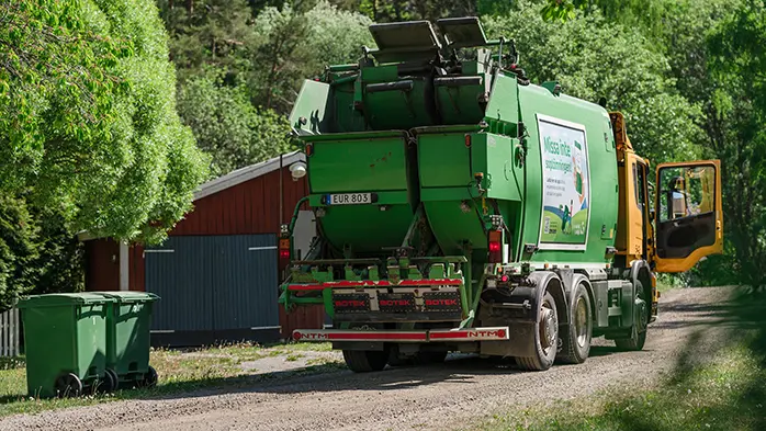En sopbil och två sopkärl.