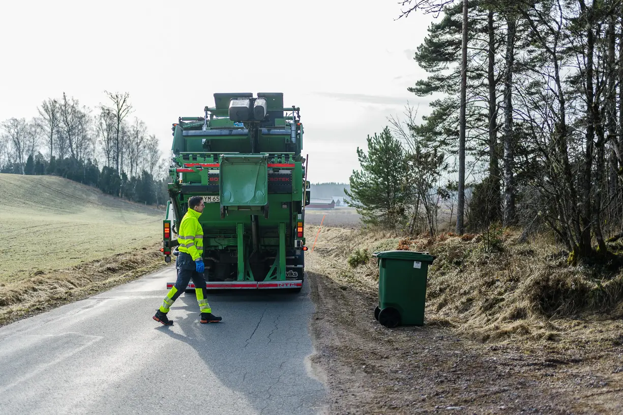 En sopchaufför hämtar ett kärl till sopbilen.