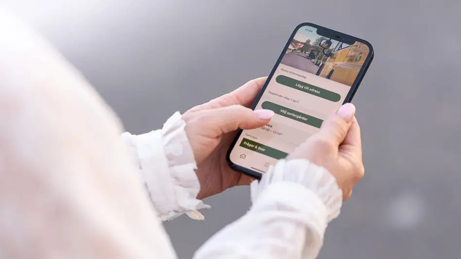 Vår app syns i en mobil som en person håller i.