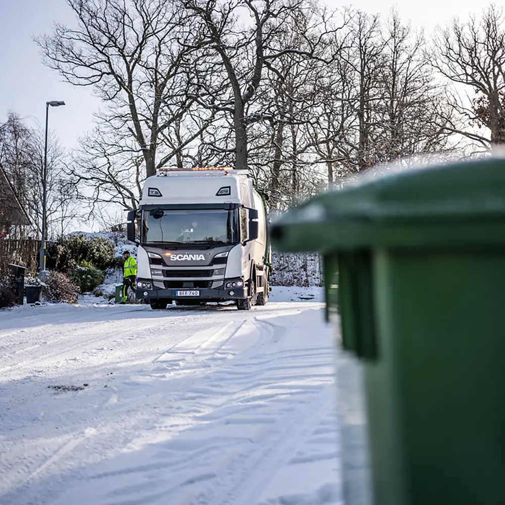 Sopbil tömmer kärl i villaområde.