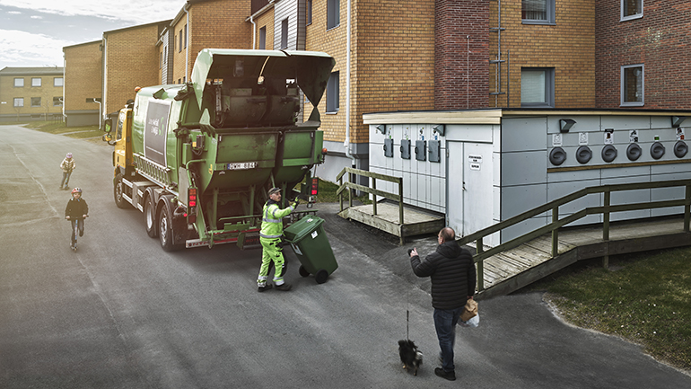 Sopbil hämtar avfall vid ett flerbostadsområde.